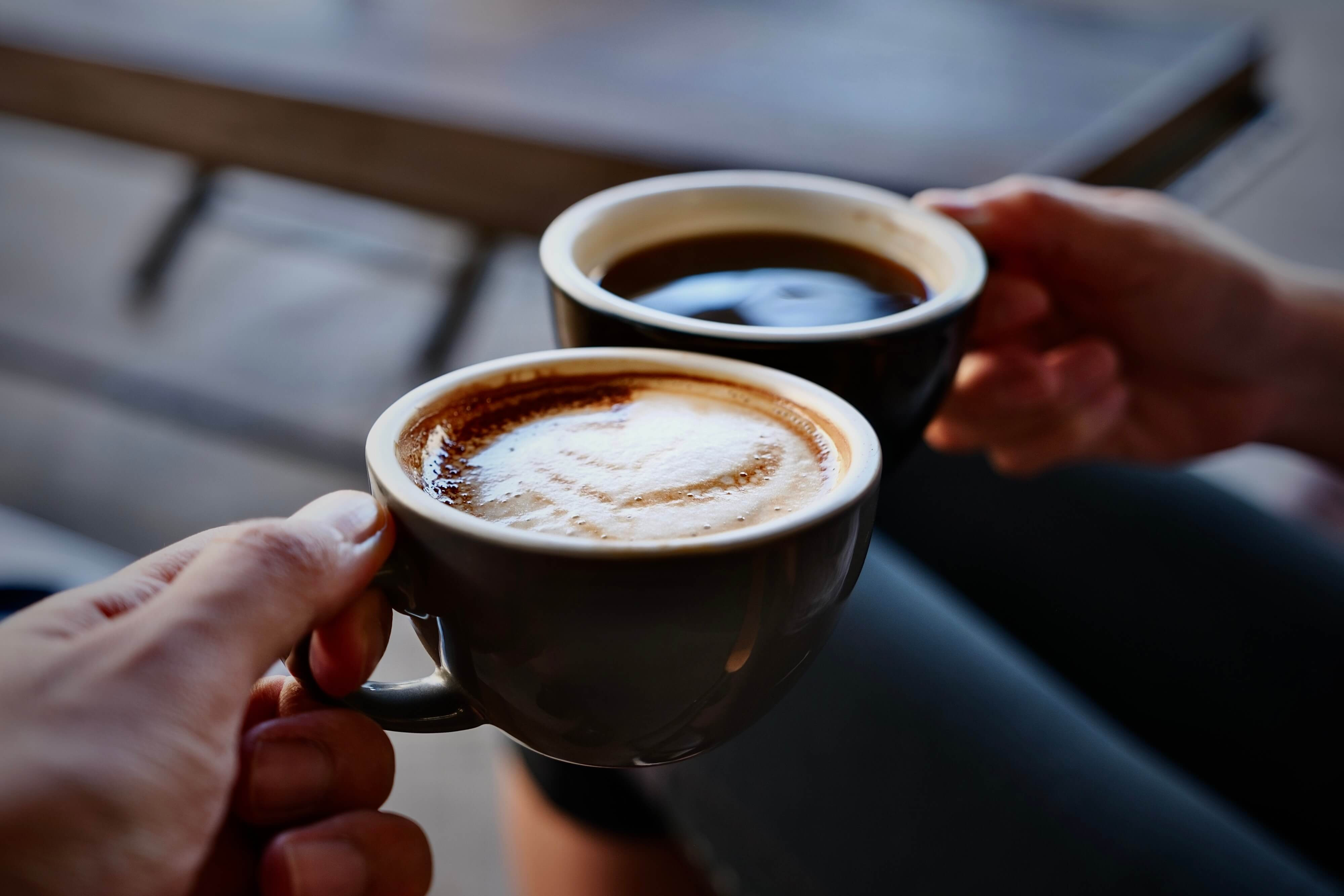 two cups of coffee held