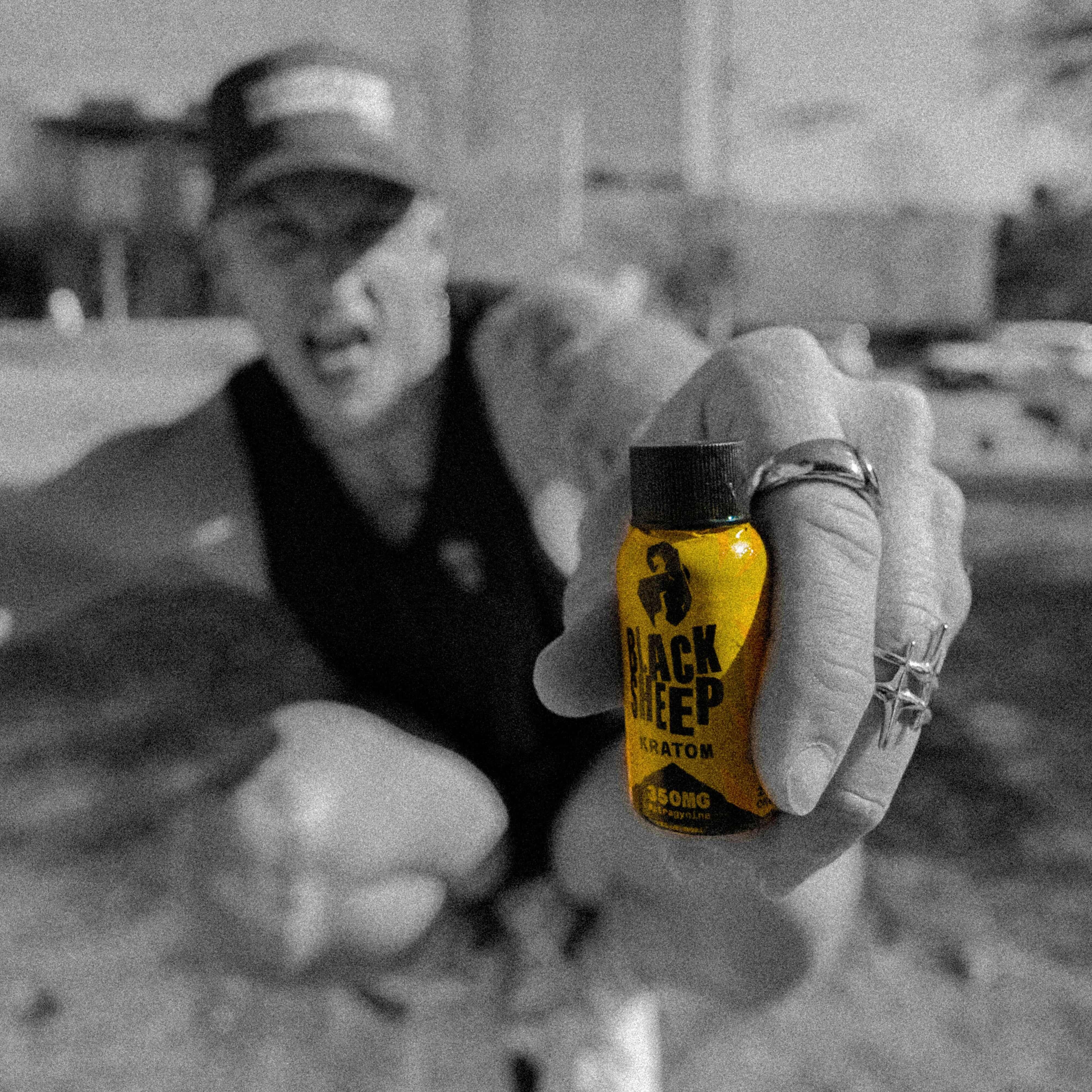man holding a kratom shot up close