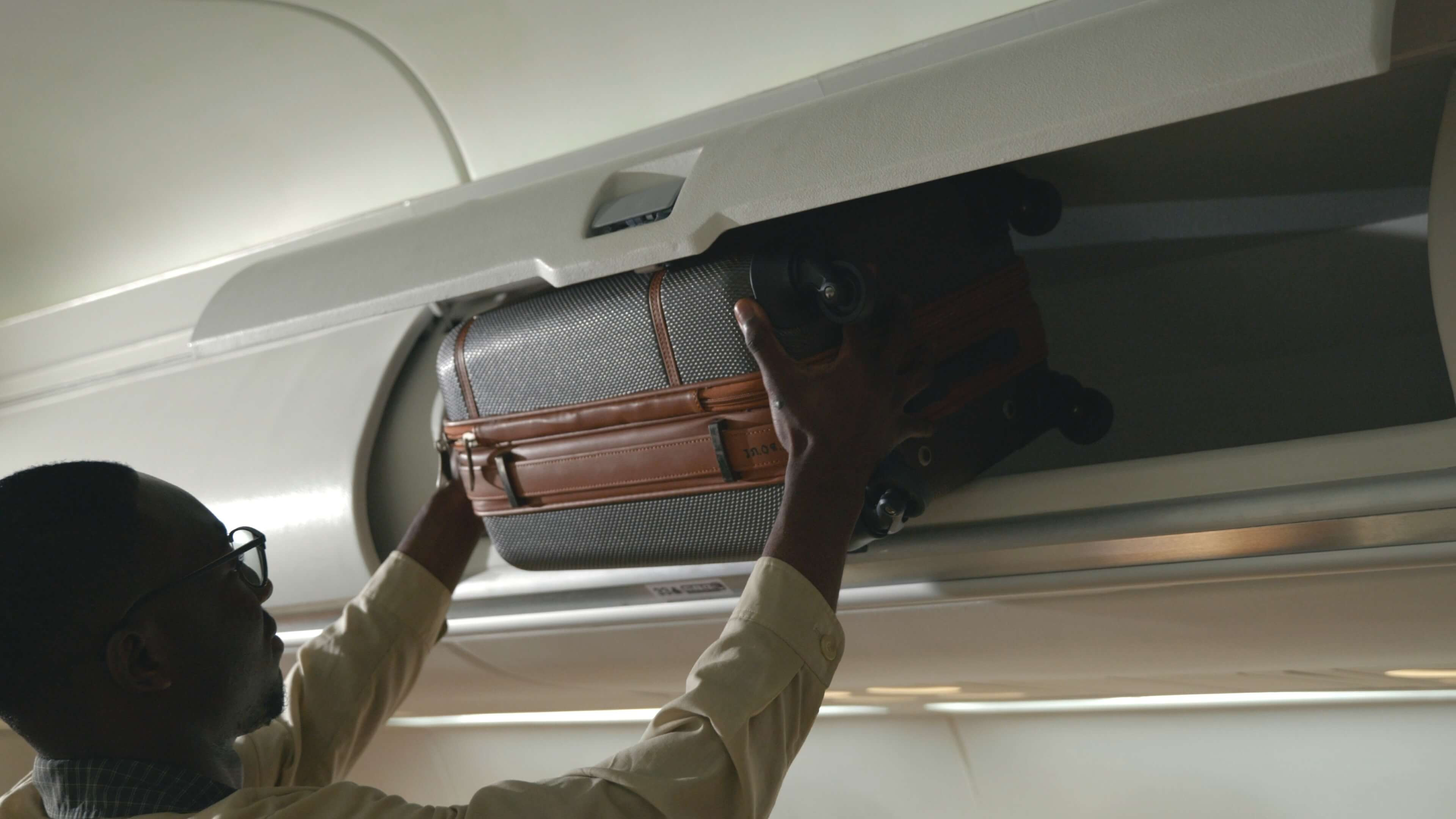 man loading luggage into plane