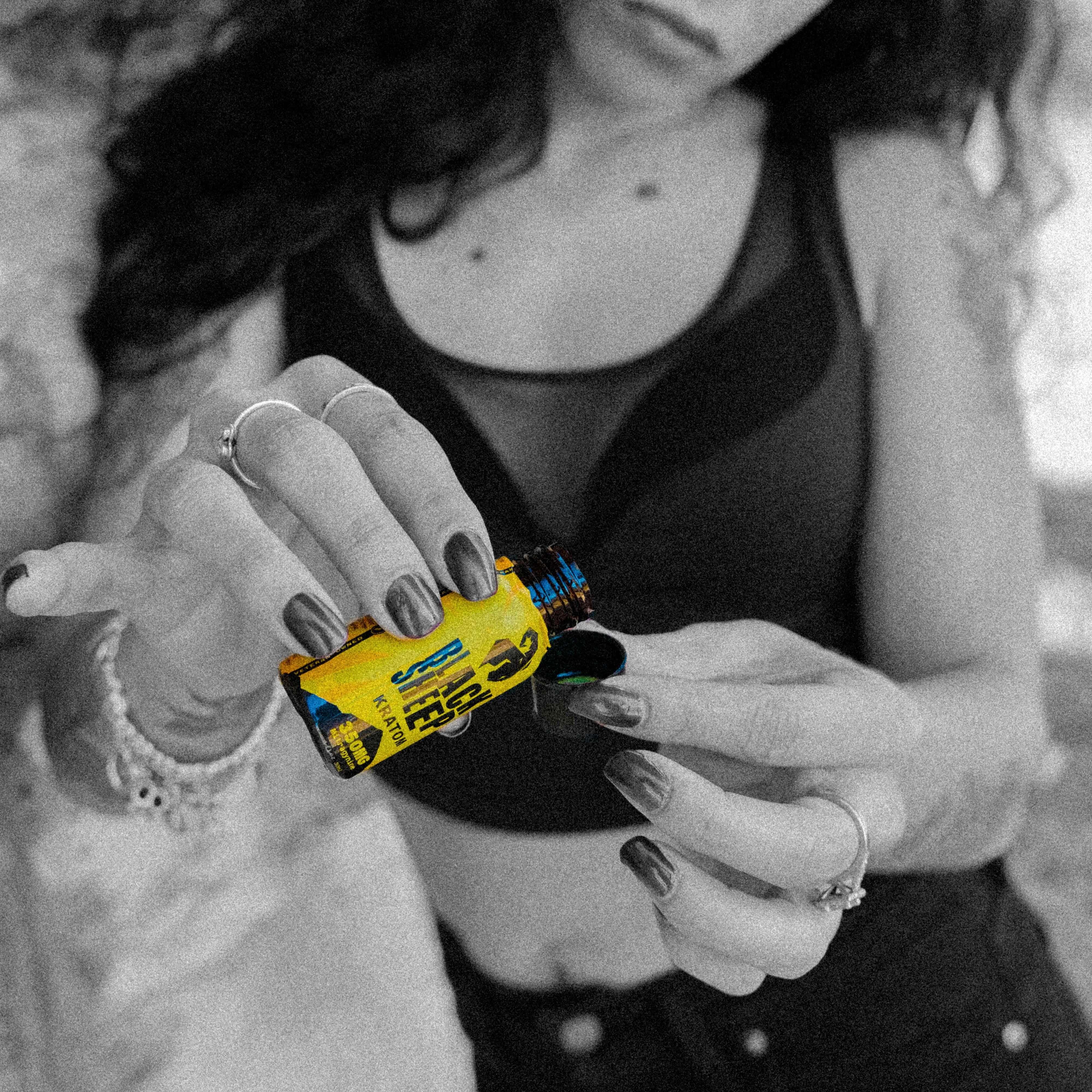 woman pouring kratom shot into cap